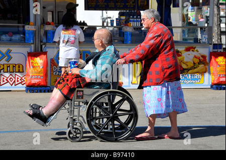 Bianco femmina Senior spinge white senior maschi obesi o in sovrappeso di disabili in carrozzella a Florida State Fairgrounds Tampa Foto Stock