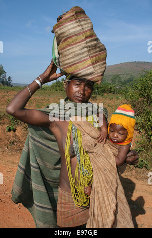 Indiano tribù Bonda Donna con bambino al Hip e borsa da trasporto sulla testa Foto Stock