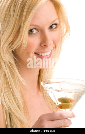 Close-up di un attraente donna bionda tenendo un coppetta Martini con olive Foto Stock