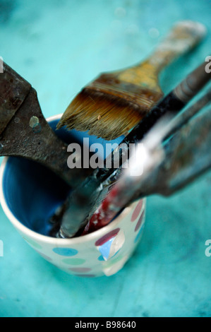Una miscela di pentole e pennelli utilizzati da artista Mike bernard nel suo studio nr Combe Martin Foto Stock