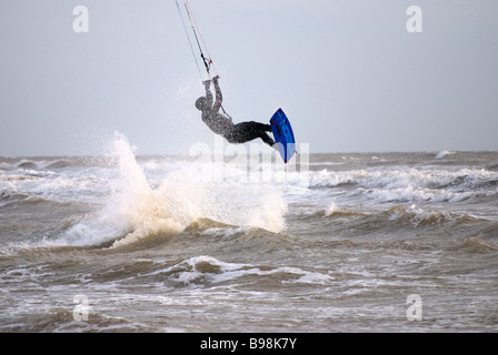 Kitesurfer off saltando attraverso l'aria fuori onda Foto Stock