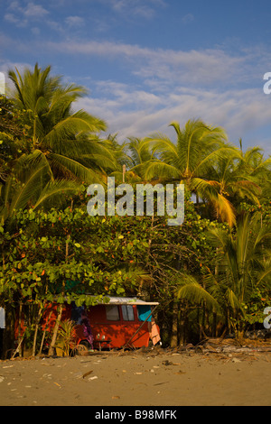 Orange Volkswagen van camping lungo la spiaggia con le palme in Dominical, Costa Rica. Foto Stock