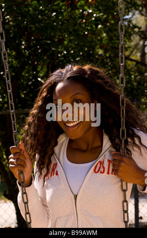 Il nero americano africano donna relax su altalena nel parco di ridere all aperto con esercizio Foto Stock