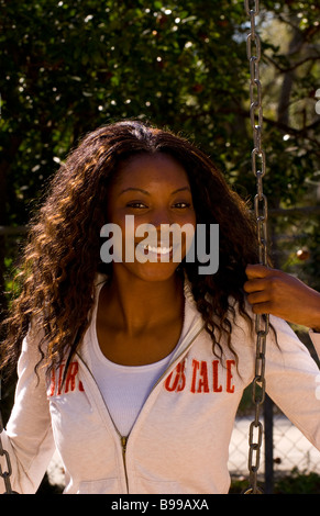 Il nero americano africano donna relax su altalena nel parco di ridere all aperto con esercizio Foto Stock