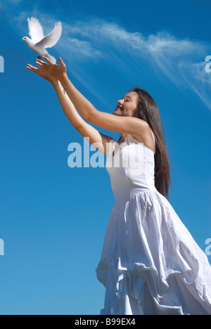 La donna felice rilasciando un piccione in cielo Foto Stock