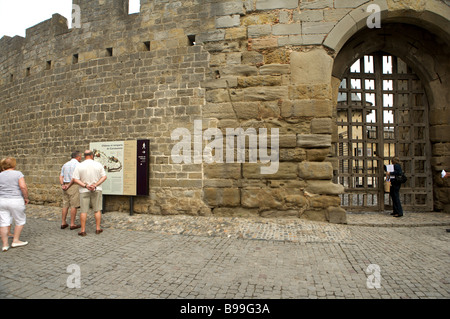 I turisti esaminare una mappa turistica al di fuori delle mura del castello di Carcassonne Languedoc Francia Foto Stock