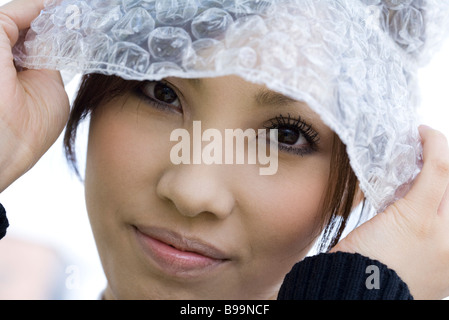 Donna che indossa cappello di Bubble wrap, ritratto Foto Stock