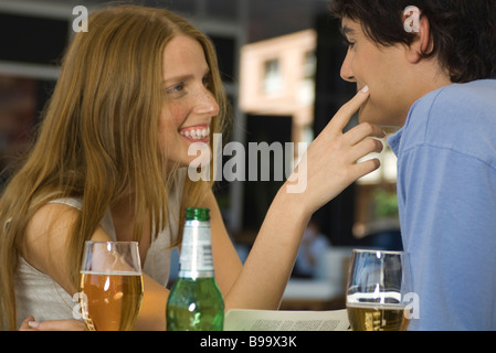 Coppia giovane in cafe, donna uomo commovente sua guancia Foto Stock