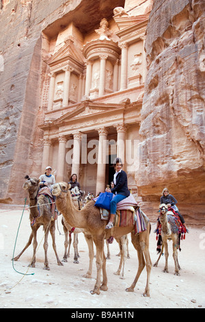 I turisti a cavallo di cammelli di fronte al tesoro, Petra Giordania Foto Stock