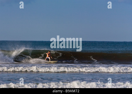 Surfer surf la rottura a Playa Dominical in Puntarenas, Costa Rica. Foto Stock
