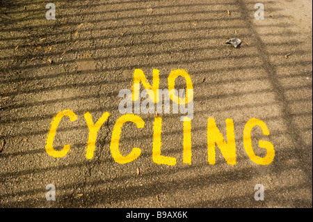 Dipinto proibitivo messaggio sul percorso in Hampstead Heath. ombra impressione di ringhiere adiacenti dà l impressione di prigione ba Foto Stock