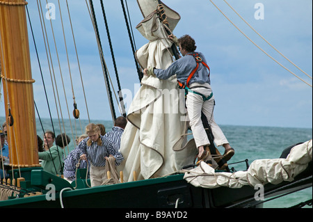 Ammainando le vele come la storica tall ship 'Amici buona volontà' arriva in Sud Haven, Michigan il suo viaggio inaugurale. Foto Stock