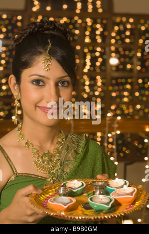 Donna che mantiene un tradizionale Diwali thali Foto Stock