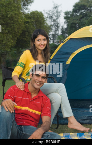 Giovane seduto di fronte a una tenda Foto Stock