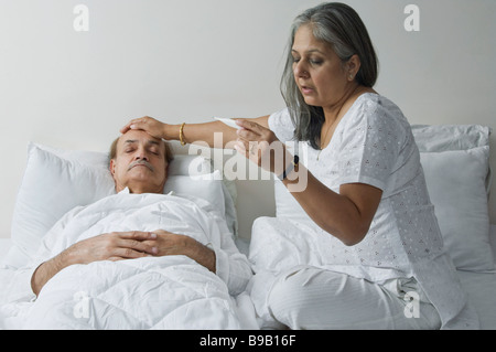 Controllo di una donna un uomo di temperatura nella camera da letto Foto Stock