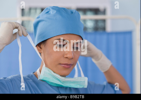 Chirurgo femmina indossare una mascherina chirurgica Foto Stock