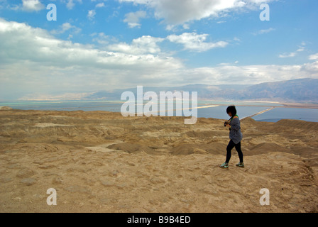 Woman Hiking trail lungo il bordo della scogliera ripida nel desolato deserto della Giudea un ex oceano pavimento vicino alla vetta del Monte Sedom Foto Stock