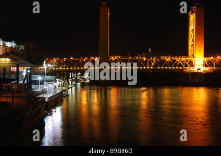 Vista di K Street Bridge e il fiume Sacramento lungo Old Sacramento riverfront di notte come si vede dal Delta King riverboat Foto Stock