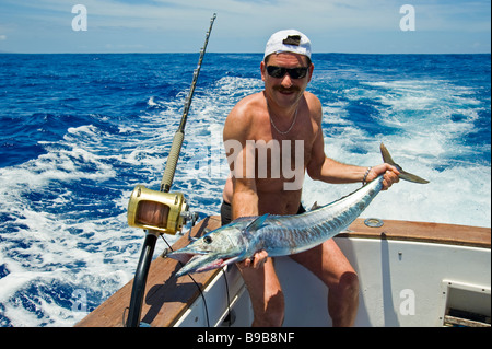 Big game fishing fisherman mostra wahoo fermo sulla barca da pesca, La Réunion, Francia | Hochseeangeln, pescatore mit Wahoo Fang Foto Stock