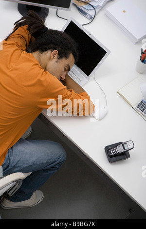 Napping Uomo alla scrivania, vista aerea Foto Stock