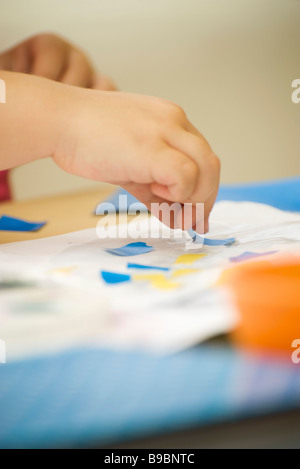 Bambino rendendo collage con colla e carta, vista ritagliata delle mani Foto Stock