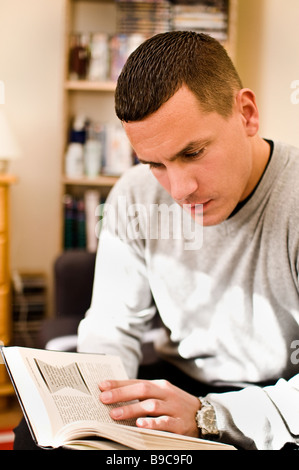 Un giovane europeo orientale uomo legge un libro Foto Stock