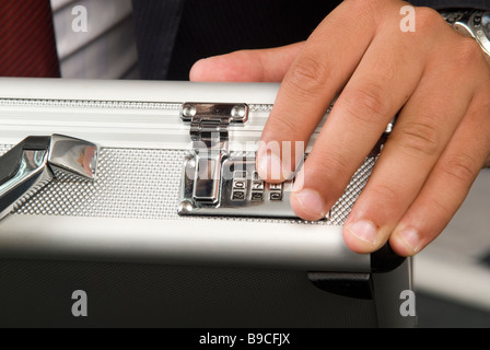 Business man sblocco di una serratura a combinazione a di una valigetta Foto Stock