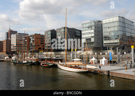 Il Traditionsschiffhafen con navi storiche a Sandtorhafen, dietro alcuni moderni edifici residenziali di Hafencity in ha Foto Stock