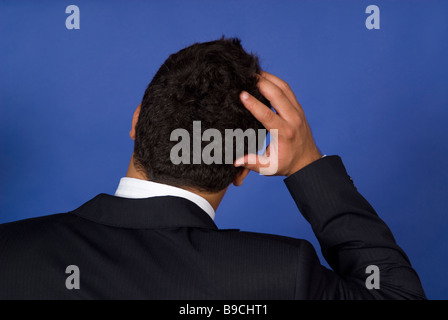 Vista posteriore di un uomo d affari di graffiare la sua testa Foto Stock