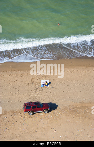 Vista aerea di una trazione a quattro ruote motrici suv, una donna lettura presso la spiaggia e un uomo di nuoto, Agacli, Mar Nero, Istanbul, Turchia Foto Stock