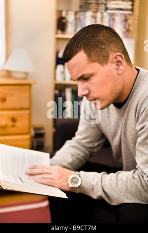 Un giovane europeo orientale uomo legge un libro Foto Stock