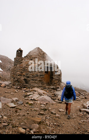 Il giorno 3 di funzionamento il John Muir Trail autonomamente. Escursionista ascende verso Muir rifugio al top di Muir Pass in Sierra Nevada. Foto Stock