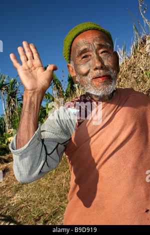 Tatuato Konyak Naga Tribe Uomo con la mano alzata nel saluto Foto Stock