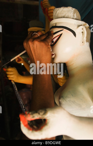 Pittore pittura su una statua della dea Durga, Calcutta, West Bengal, India Foto Stock