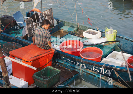 Pescatore sulla barca, Tai O, Lantau, Hong Kong Foto Stock