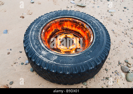 Un vecchio carrello ruota e pneumatico lavato fino a una spiaggia del Regno Unito Foto Stock