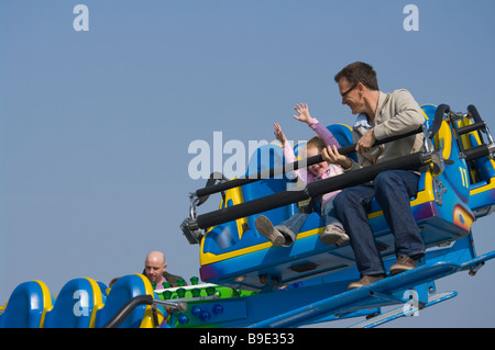 Padre e figlia persone a cavallo godendo di una fiera fiera del divertimento Luna park Ride su il Palace Pier Brighton East Sussex England Foto Stock