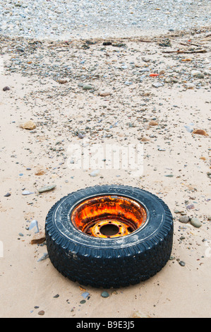 Un vecchio carrello ruota e pneumatico lavato fino a una spiaggia del Regno Unito Foto Stock