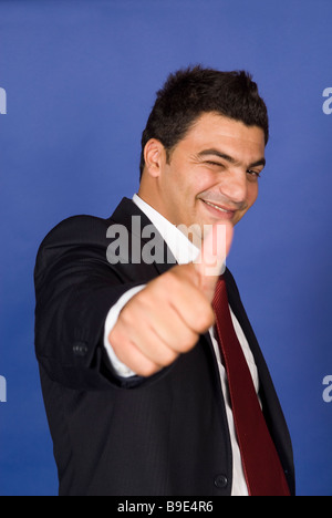 Business man winking e pollice in alto Foto Stock