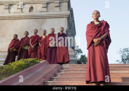 I monaci in piedi di fronte a un tempio, tempio di Mahabodhi, Bodhgaya,, Gaya, Bihar, in India Foto Stock