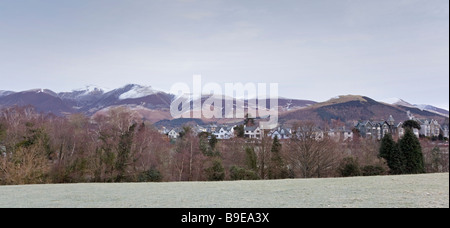 Cime innevate della gamma Skiddaw salire dietro il distretto del Lago Città di Keswick in Cumbria Foto Stock