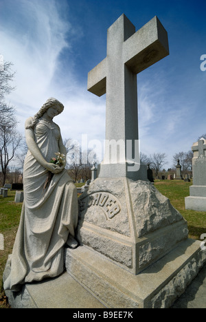 Un monumento di una donna (Maria Maddalena?) e una croce in Cristo nostro Redentore Cimitero Cattolico di Pittsburgh, in Pennsylvania. Foto Stock