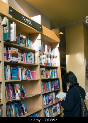 UK.Visitatore leggendo un libro nella sezione viaggi alle frontiere Bookshop,Londra,Inghilterra.Foto di Julio Etchart Foto Stock