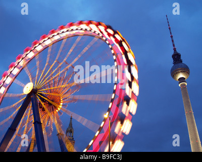 Basso angolo di vista ferries wheel e torre di comunicazione contro dusky sky Foto Stock