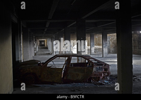 Un'auto bruciata abandonned sul parcheggio sotterraneo di un piatto del Consiglio (Francia). Carcassa de voiture calcinée dans un sous-sol Foto Stock