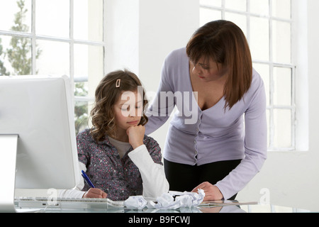 Donna aiutare la propria figlia nello studio Foto Stock