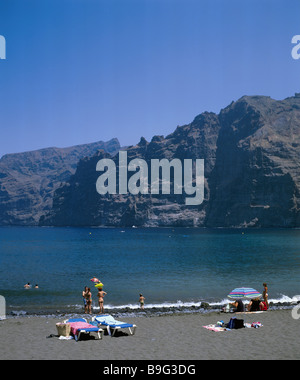 Spagna Isole Canarie Tenerife costa molto Gigantes lava - spiaggia di sabbia nera rockfaces nuotatori lago vulcano-isola mare Foto Stock