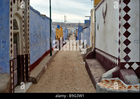 Coloratissima strada laterale di Nubian Village mostra case e strada polverosa nell'Egitto meridionale sulla riva occidentale del fiume Nilo, a nord di Aswan Foto Stock