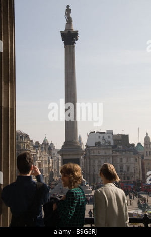 3 per i visitatori in cerca su Trafalgar Square e Nelson la colonna a Whitehall dalla National Gallery di Londra Foto Stock