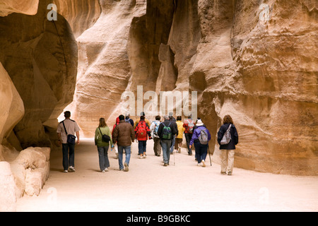 I turisti in un tour guidato a piedi attraverso il Siq sul loro modo di Petra, Giordania Foto Stock